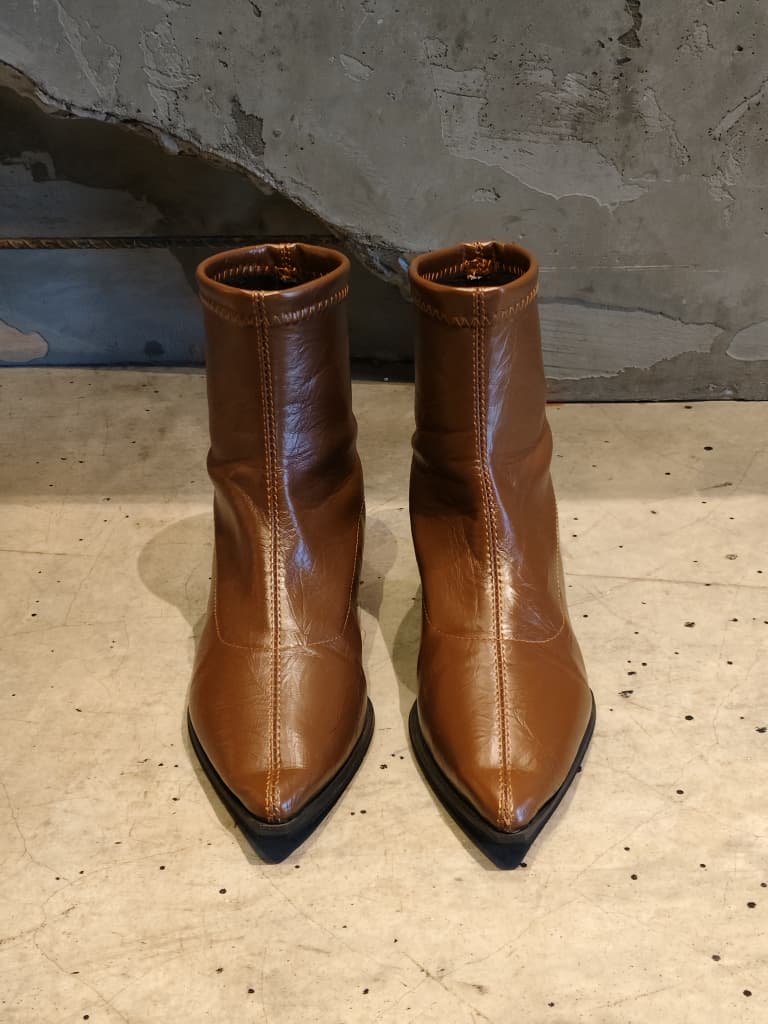 Front view of shoes in vegan leather boots in brown showing the sole unit and upper silhouette