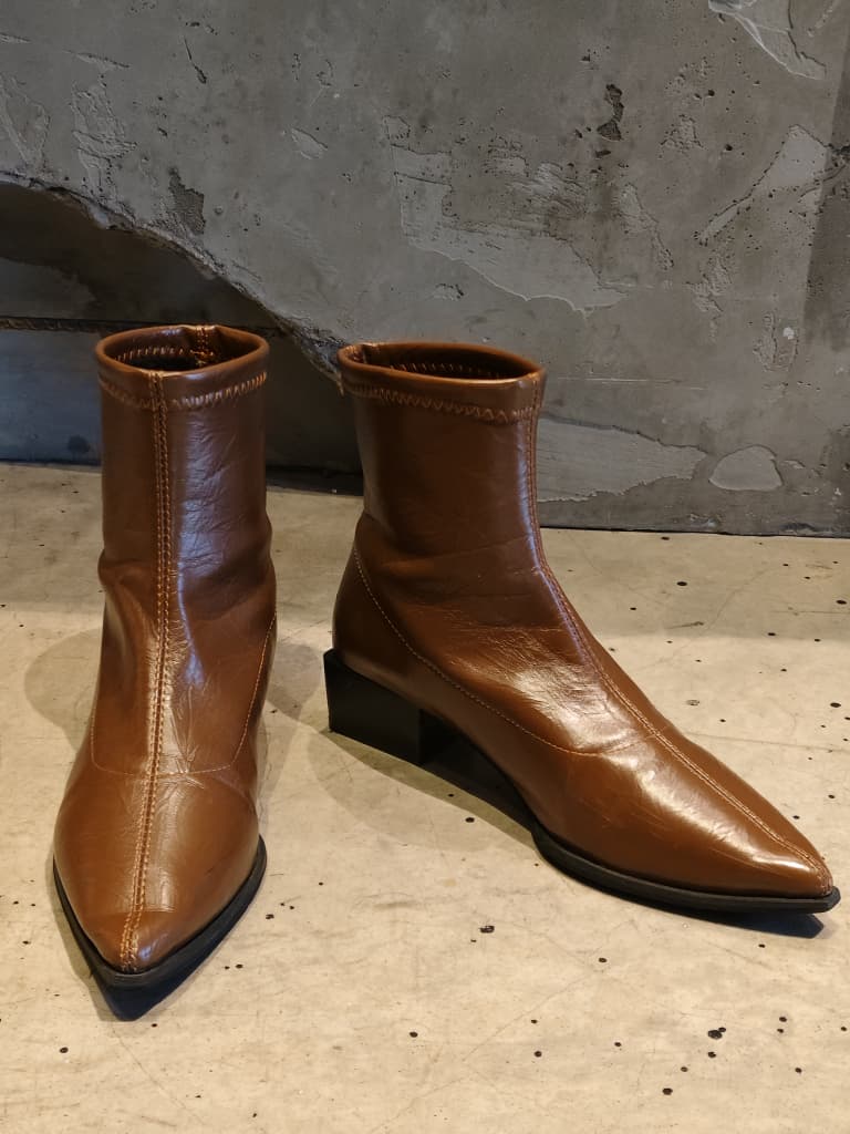 Front view of shoes in vegan leather boots in brown showing the sole unit and upper silhouette