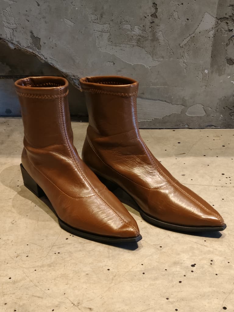 Front view of shoes in vegan leather boots in brown showing the sole unit and upper silhouette