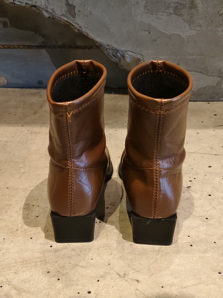 Front view of shoes in vegan leather boots in brown showing the sole unit and upper silhouette