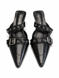 Pair of black leather pointed-toe shoes with buckles and grommets on a white background