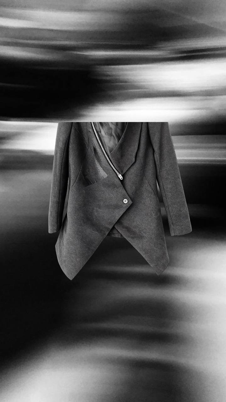 Dark wool coat with diagonal zip detail and architectural cut